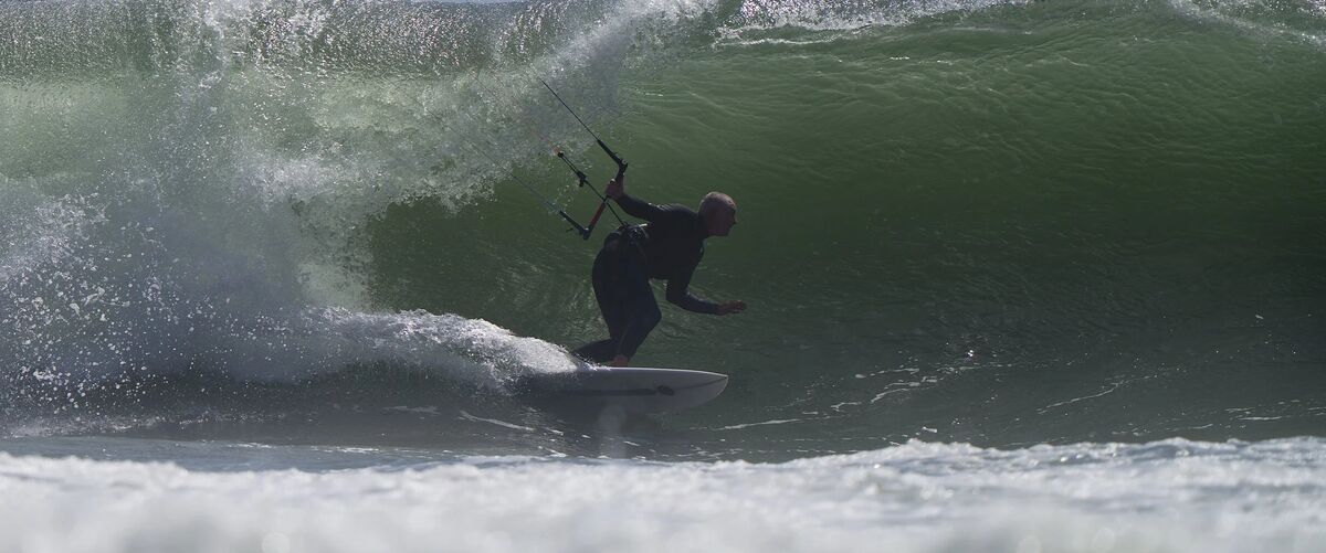 Kitesurfer riding inside a wave on a Vince Broglio kiteboard